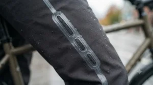 Close-up of a taped, waterproof zipper on black cycling pants.