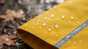 Close-up illustration of a durable waterproof fabric on a rain jacket for dog walking in Canadian spring showers.